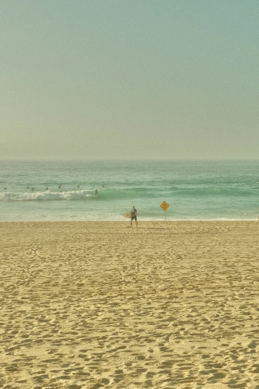 an ocean beach with people holding a small board