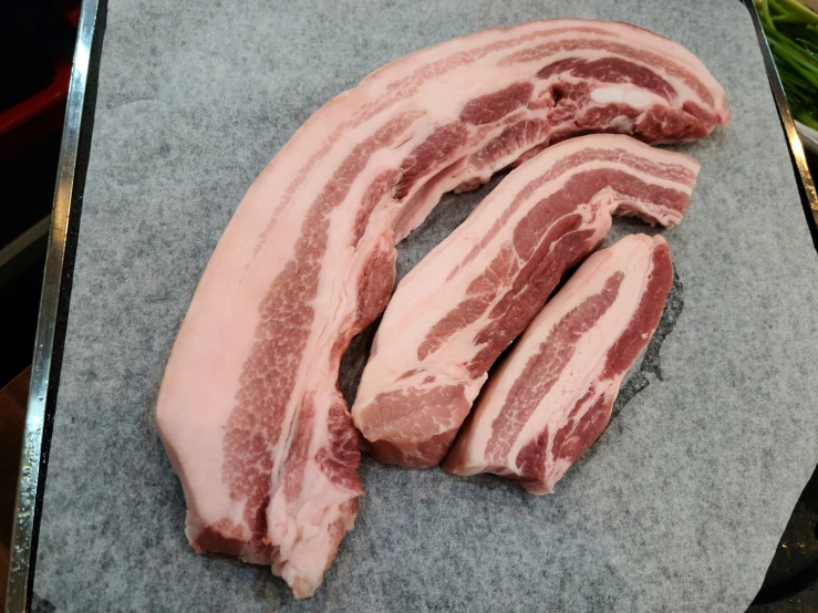 slices of raw meat sit in the middle of a  board