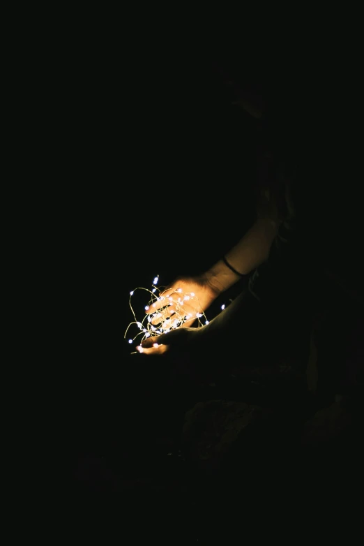 an illuminated hand in the dark with lights