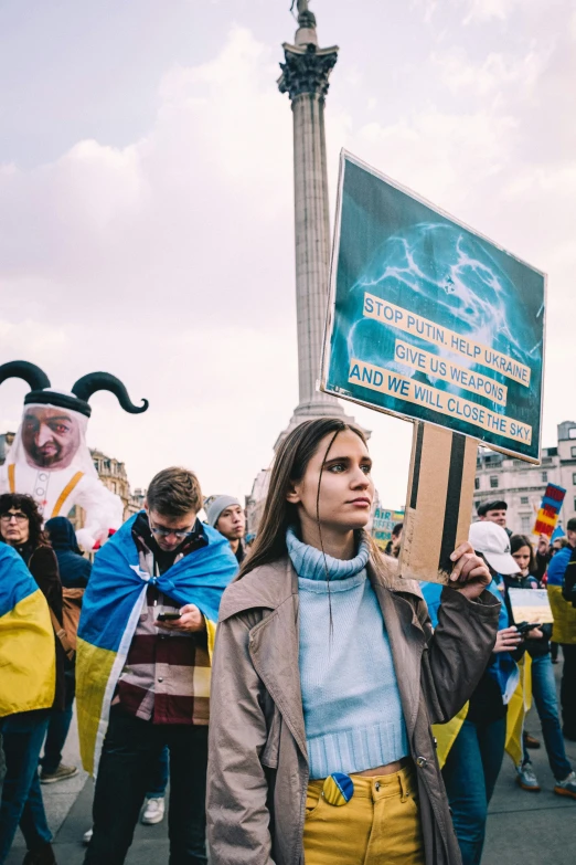 woman holding up a sign during a rally with other people