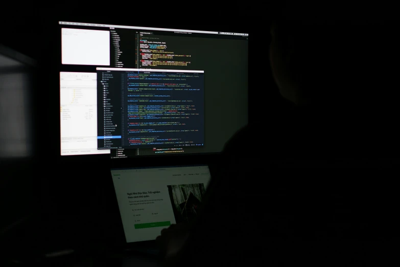 a man sitting in front of a computer screen