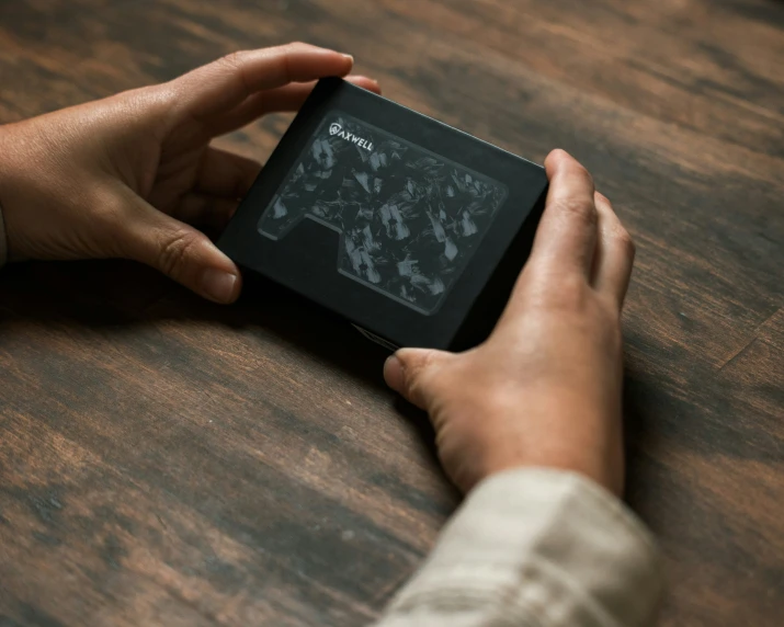 a person holding up a small digital device