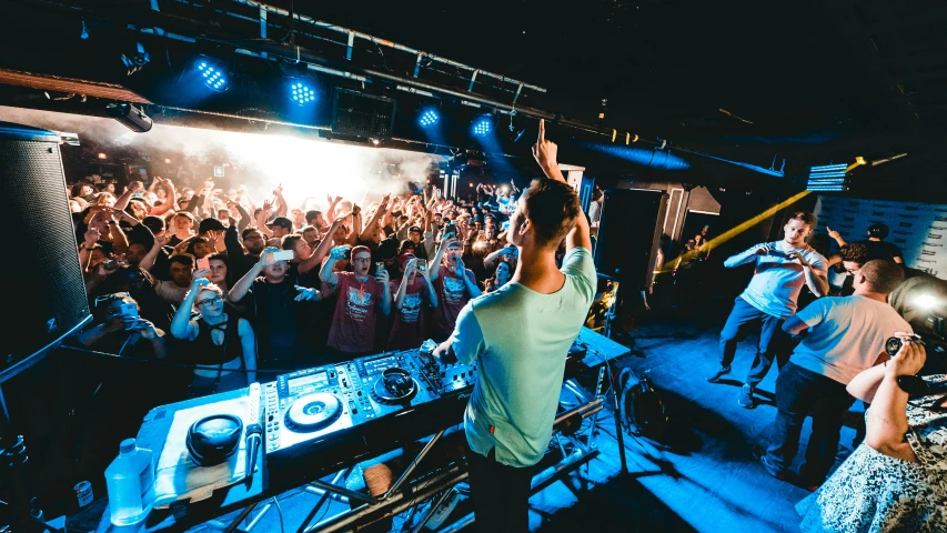 a group of people with dj controllers are standing in front of the stage