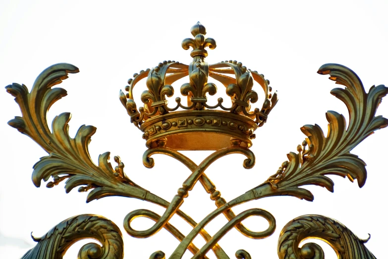 the crown is resting on top of the ornate iron fence