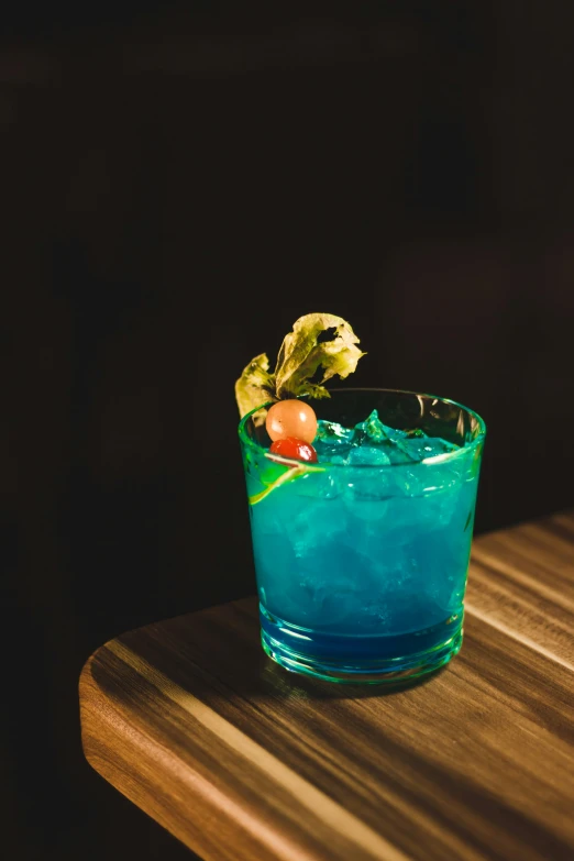 a blue drink sits on a wooden table