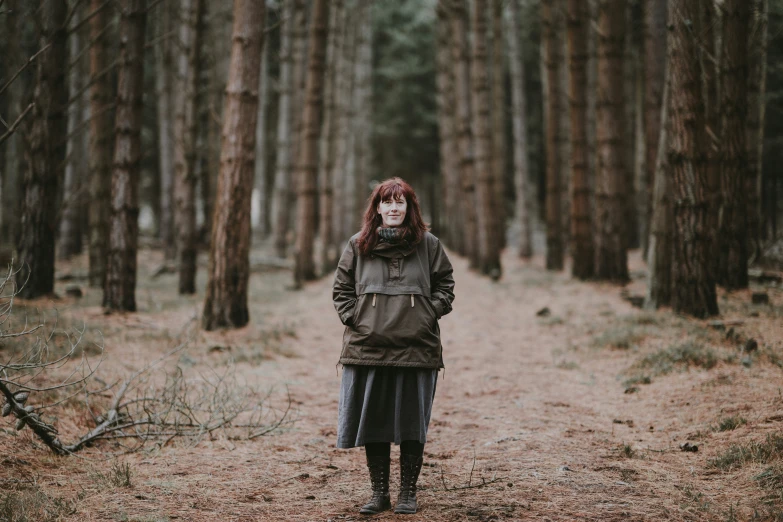 a woman is posing in the middle of the woods