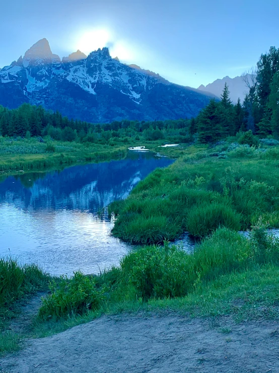 the water is still green and blue, as a mountain is in the background