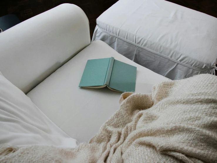 a book lying on a couch with a blanket