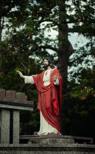 a statue of jesus with trees in the background