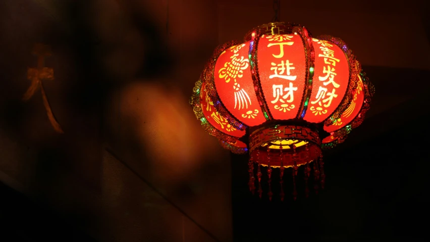 a lantern with chinese writing on it is illuminated