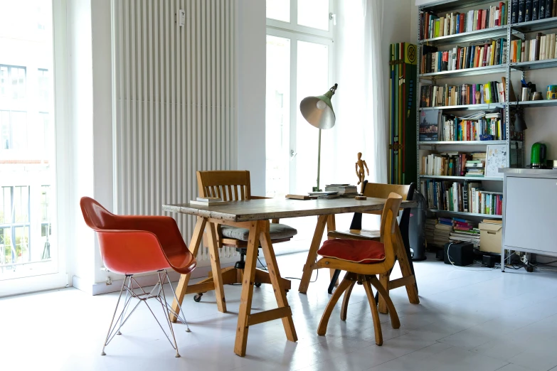 a table with chairs in front of a bookshelf filled with books