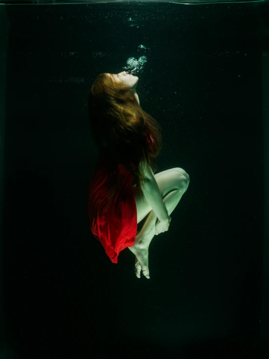 a female underwater po of a woman in a red dress