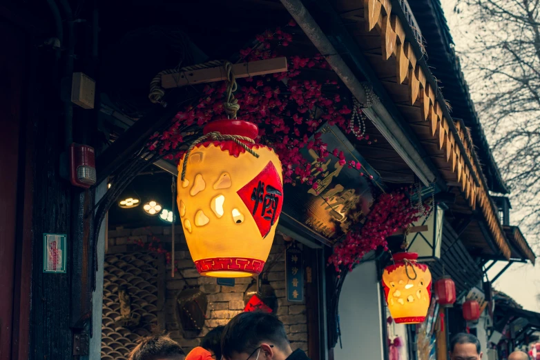 a bunch of red lanterns hanging from the side of a building