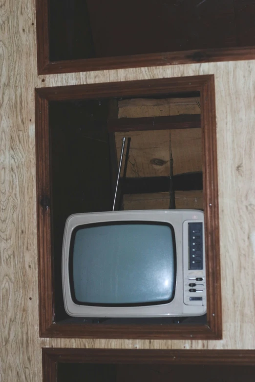 a small tv with an antenna is sitting in the corner