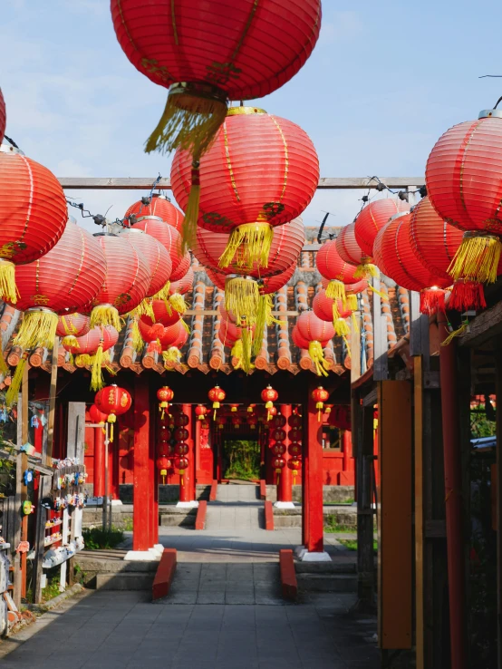 lots of red lanterns hanging above a walkway