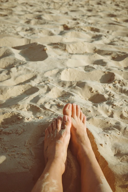 a person has their feet in the sand on the beach