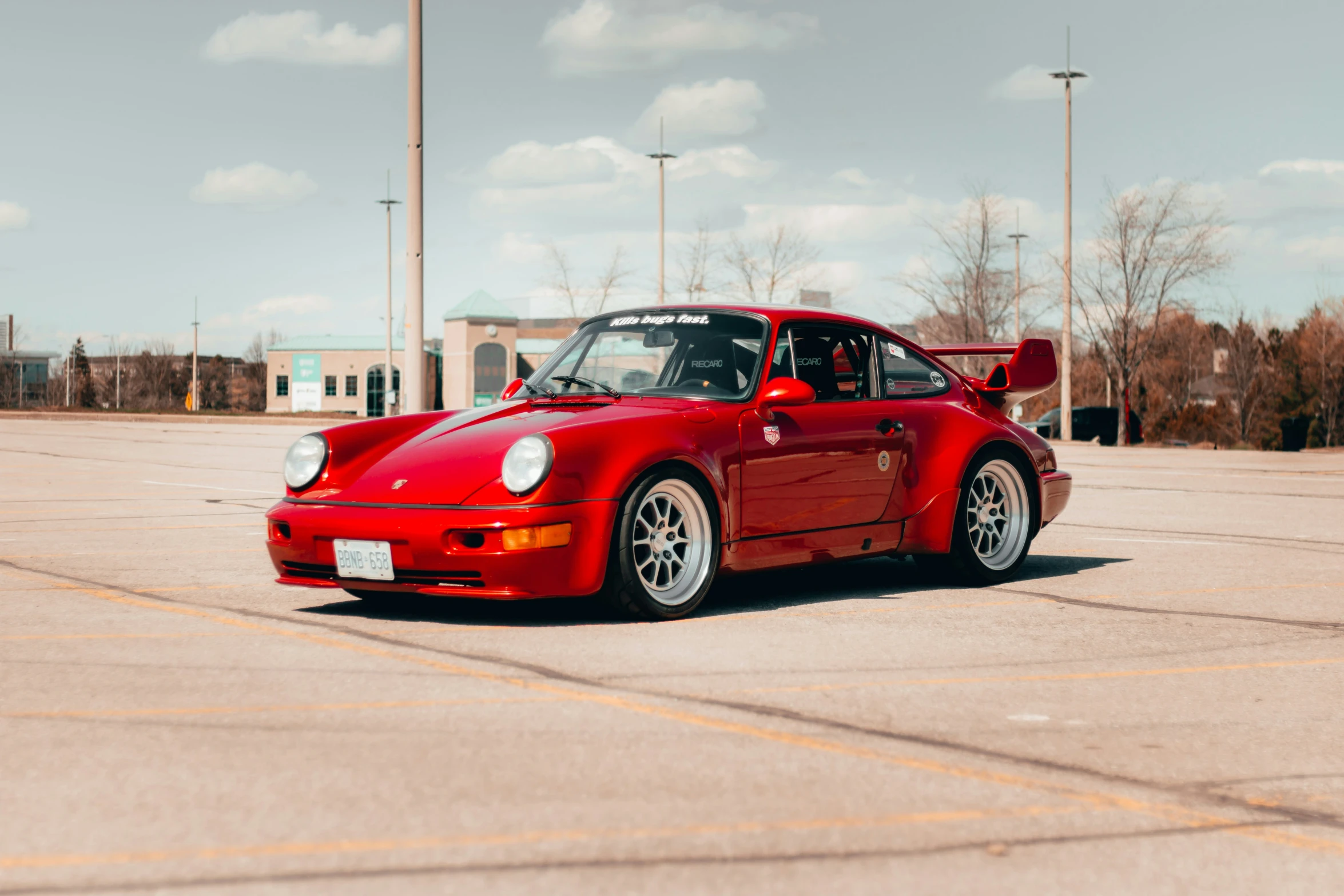 red porsche 911 tard on a concrete lot