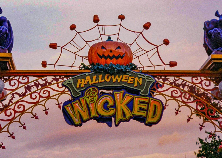 the sign for halloween is neon, a pumpkin carved into it