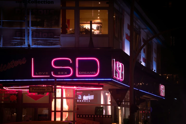bright neon signs are in the windows of a store