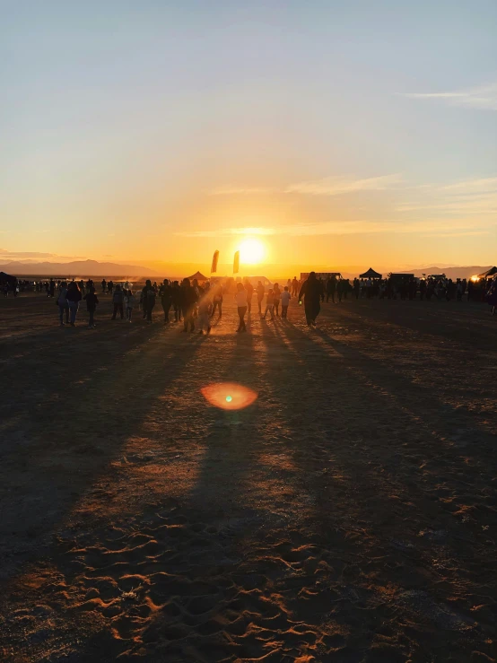 many people walking in the dirt into the sun