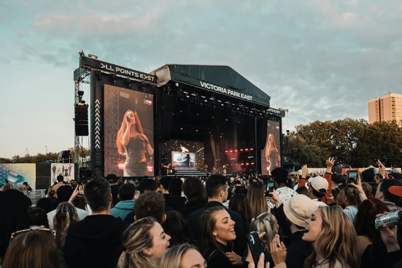 the crowd of people are standing under large screens