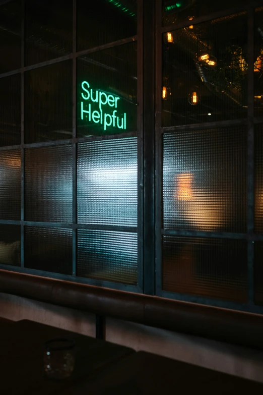 the sign is glowing behind glass in front of a restaurant