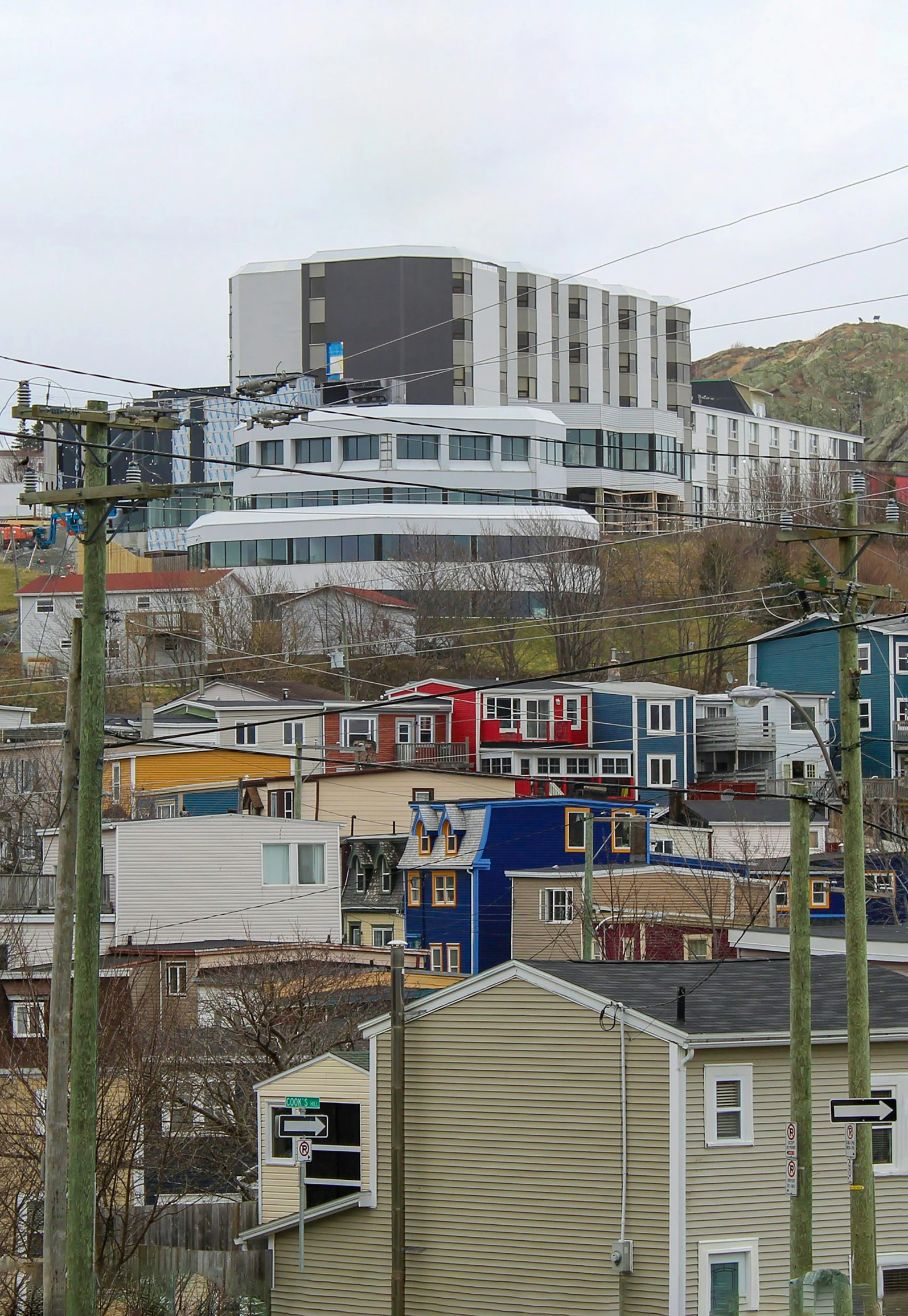 houses stand on the side of the hills next to some telephone poles