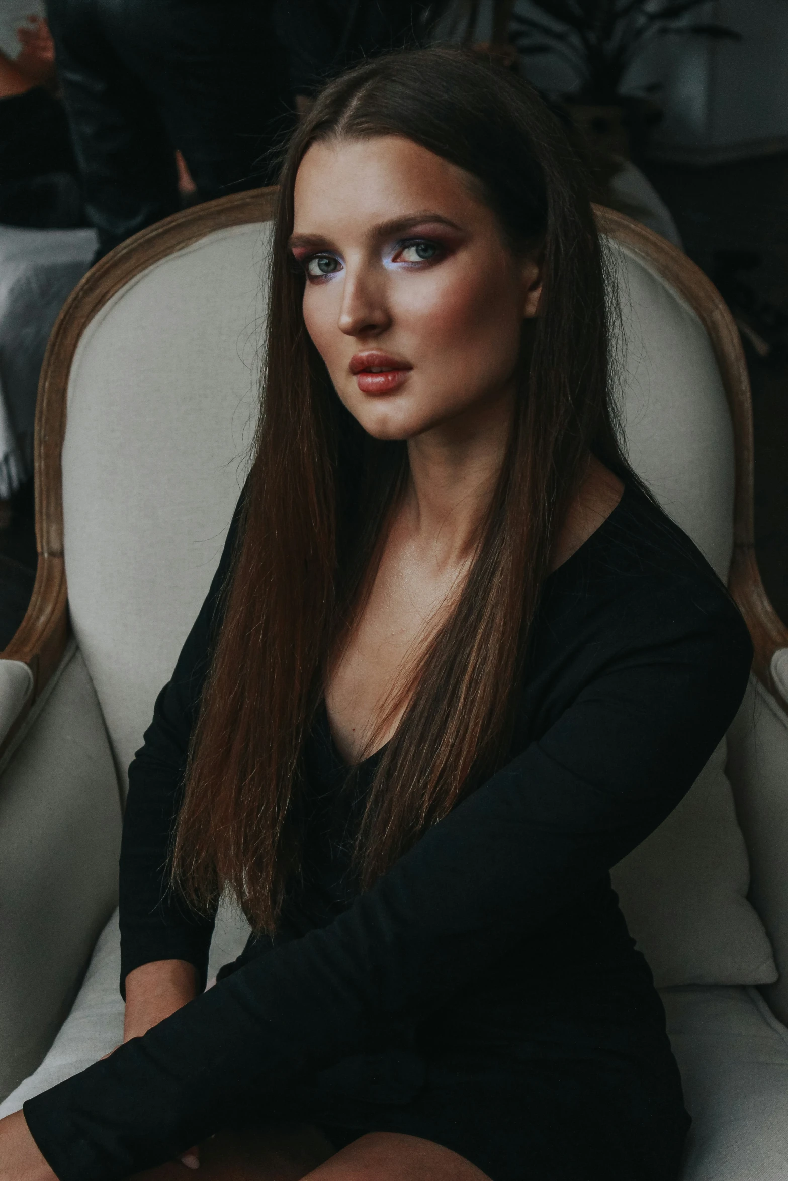 a woman sitting on a chair with her hair falling