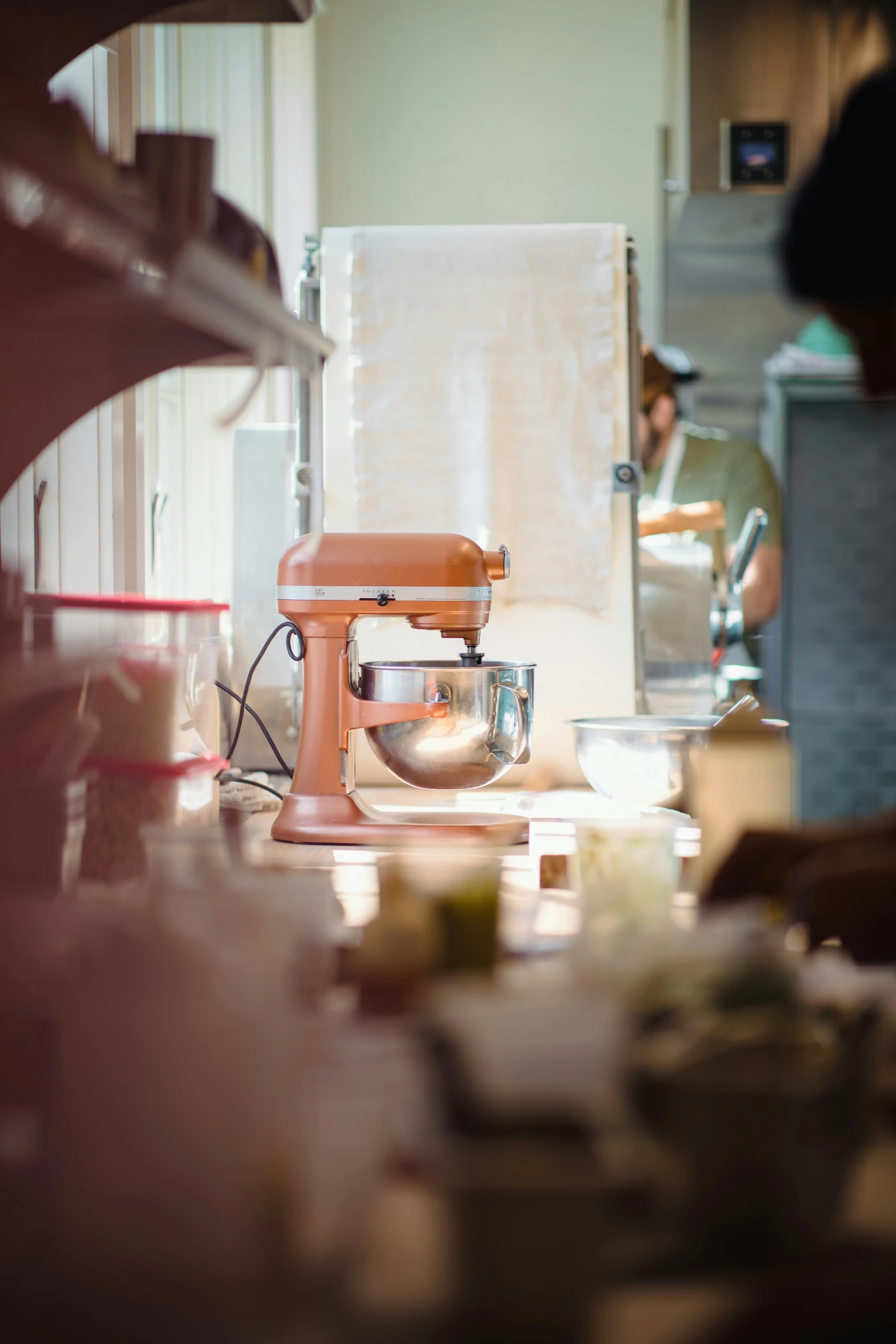 a pink mixer sits in a white kitchen