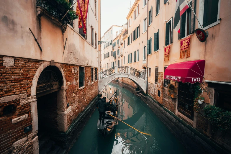two gondola boats are going down the canal of a narrow, mean