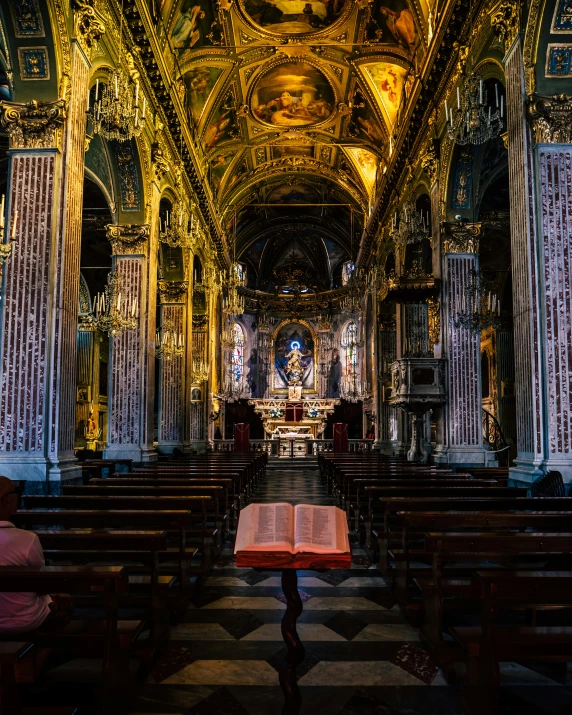 a large cathedral with an illuminated alter and wooden benches