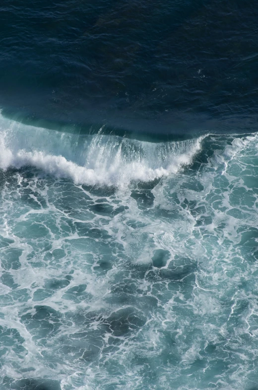 this is an aerial view of the ocean with a wave