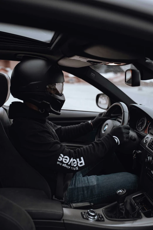 man wearing helmet and jacket sitting in vehicle with dashboard