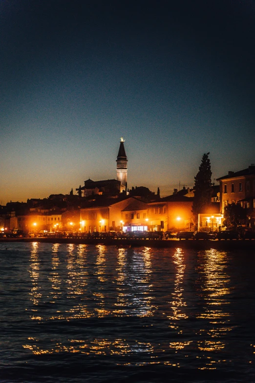 night view over a river with a clock tower in the background