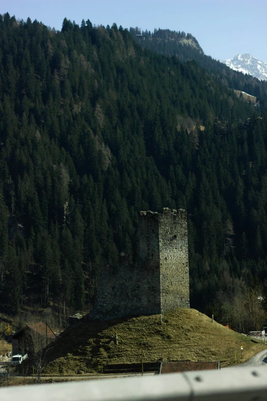 a small tower is sitting atop a grassy hill