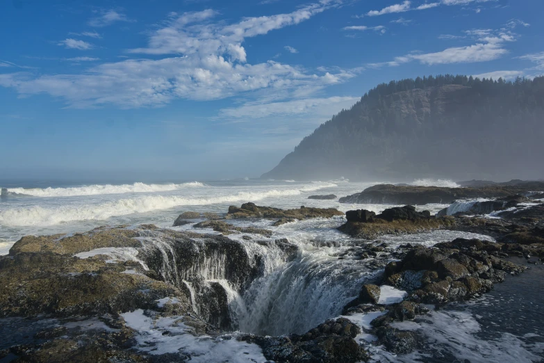 the water splashes down on rocks next to a cliff