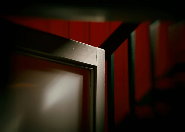 the corner of a red paneled wall is shown with metal strips