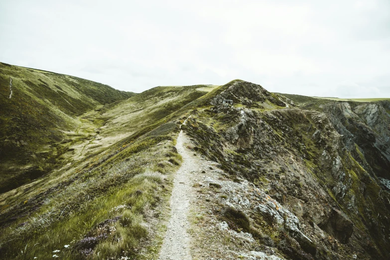 there is a large mountain that has grass and rocks