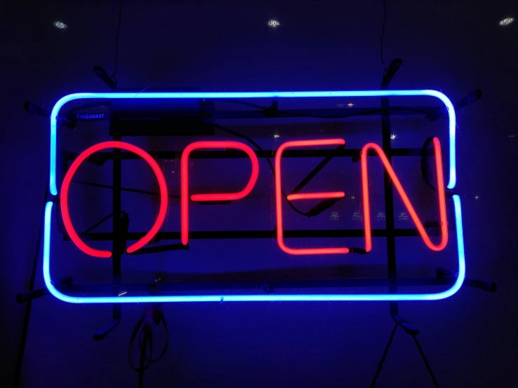 an open sign in a dark room with blue lights