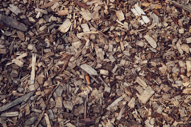 a pile of chopped wood with wood chips and a black object in it