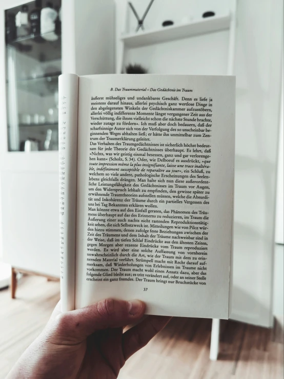 a person is holding an open book in the living room