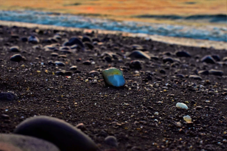 a sea glass sitting on a rocky beach