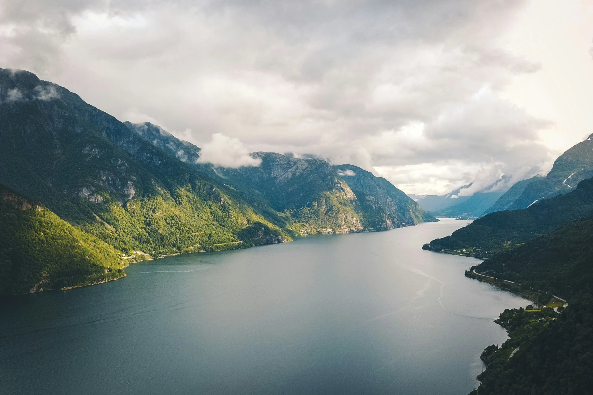 an aerial view of water and trees in the mountains