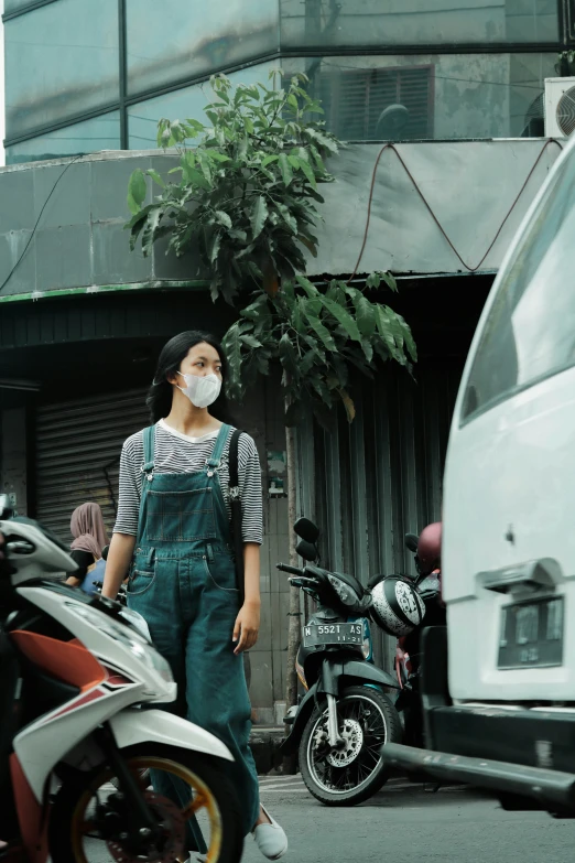 an asian woman wearing a protective mask walking on the street