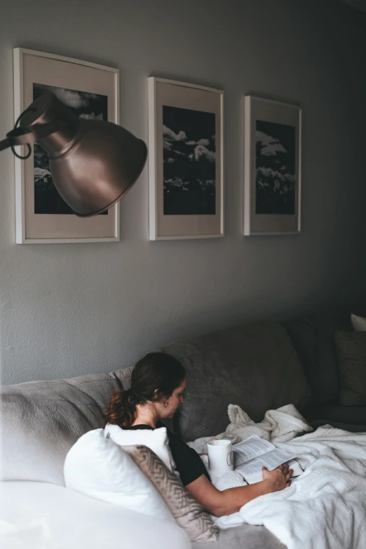 a girl lays in bed reading her book