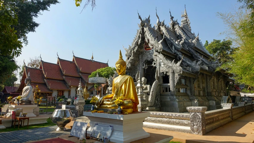 a golden buddha statue in front of a building