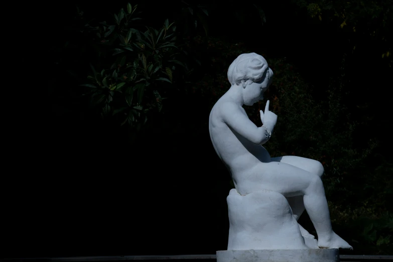 a statue sits on the ground next to trees