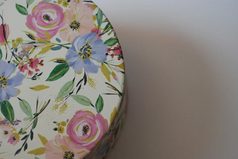 a colorful flowered container sits on top of a white counter