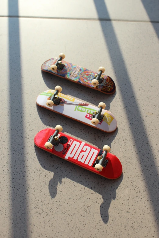 four skateboards on the ground, three red, one white and one yellow