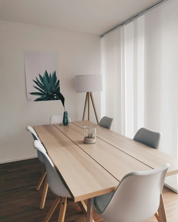 an empty dining room table with three chairs and a vase of flowers on it